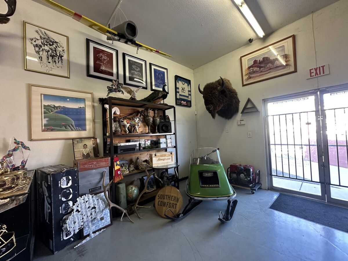 Inside Legacy: framed art, collectibles, a vintage snowmobile, and a bison mount